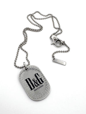 Vintage 2000s Dolce & Gabbana D&G logo dog tag necklace with silver-tone speckled pendant, ball chain, and branded lobster clasp on white background.