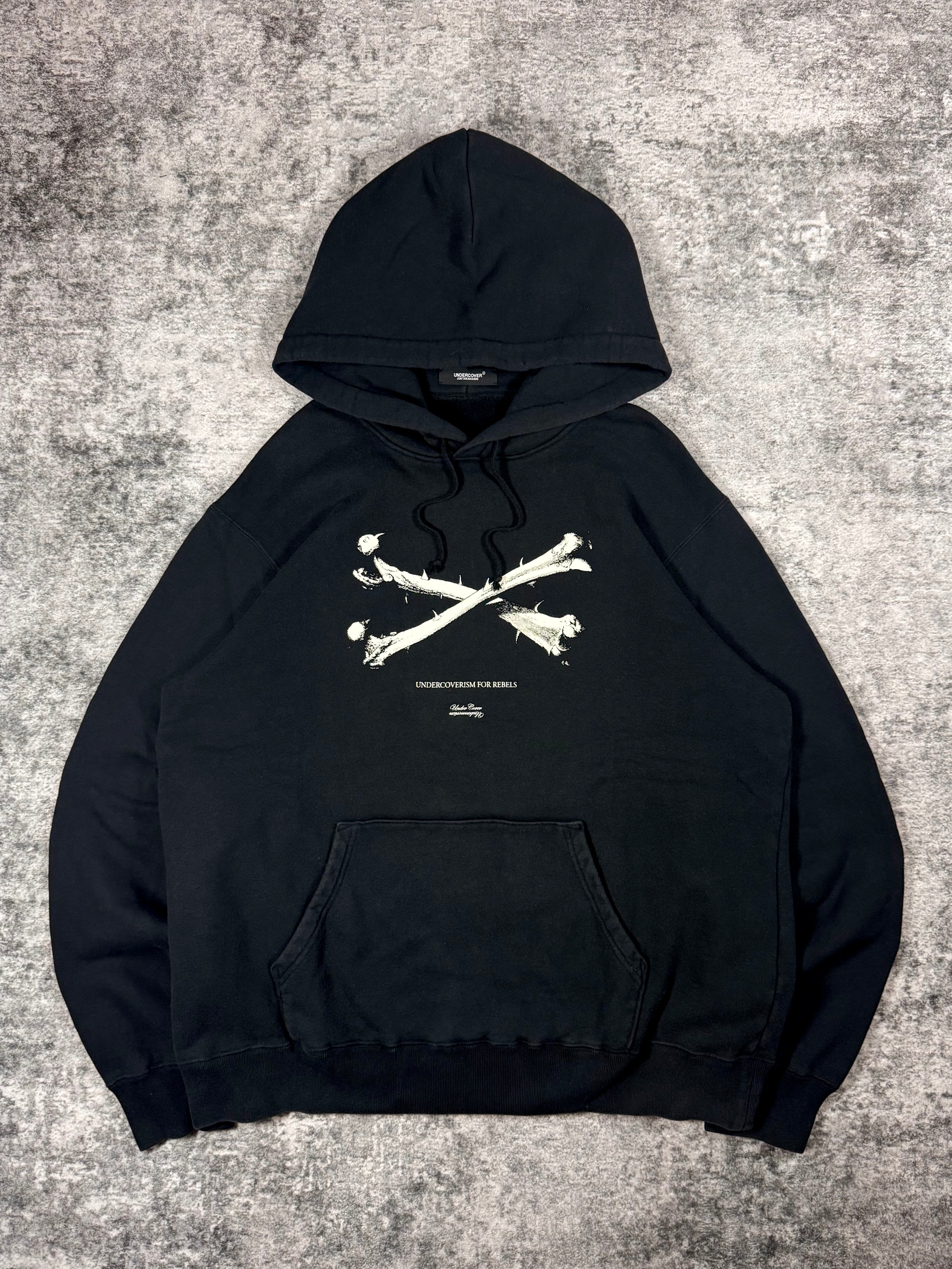 Front view of AW21 Undercover black bone graphic hoodie with Undercoverism For Rebels print