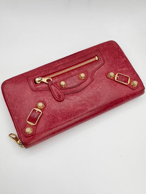 Red Balenciaga ‘Rouge’ wallet with gold accents on a white background 