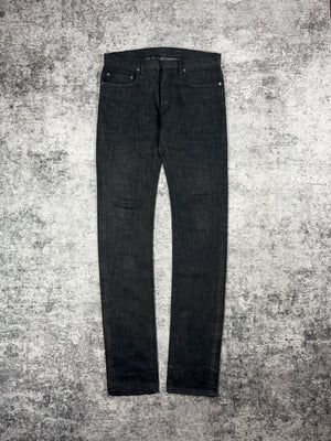 Unaltered Dior Homme Black Clawmark Jeans by Kris Van Assche on a textured gray surface
