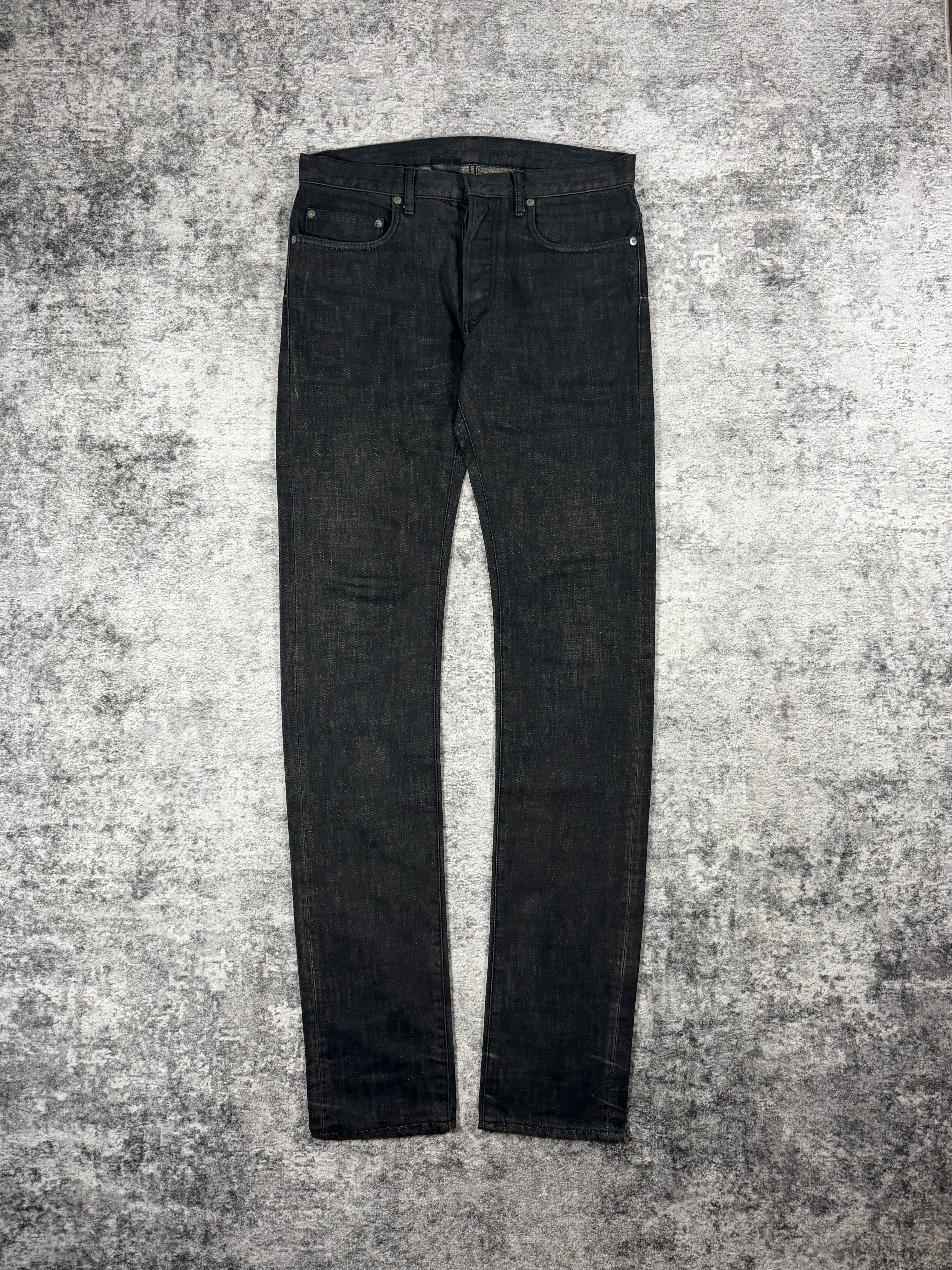 Unaltered Dior Homme Black Clawmark Jeans by Kris Van Assche on a textured gray surface
