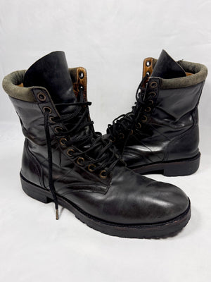 Black Number (N)ine FW08 leather combat boots with lace-up front and side zipper In front of white background 