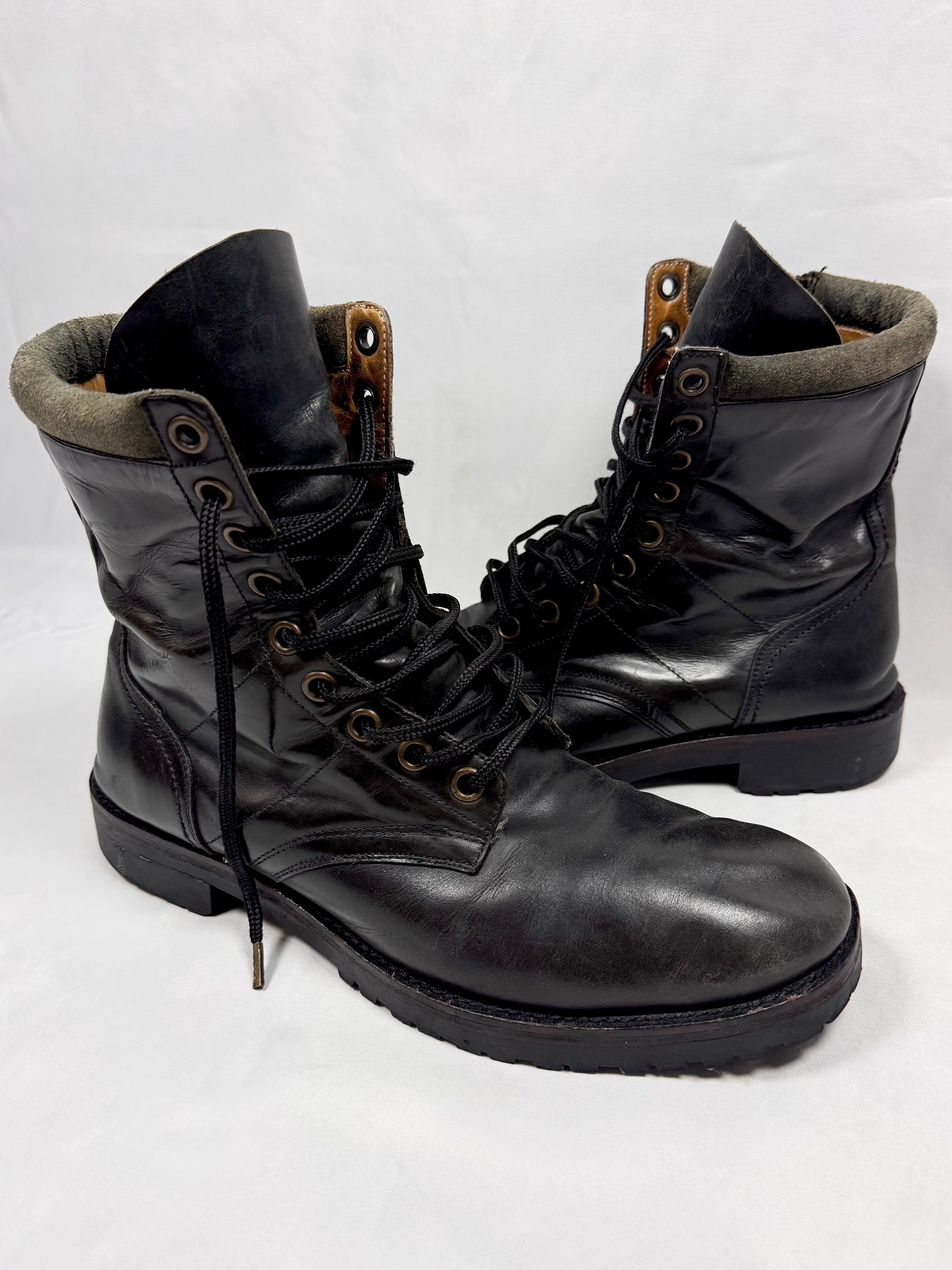 Black Number (N)ine FW08 leather combat boots with lace-up front and side zipper In front of white background 