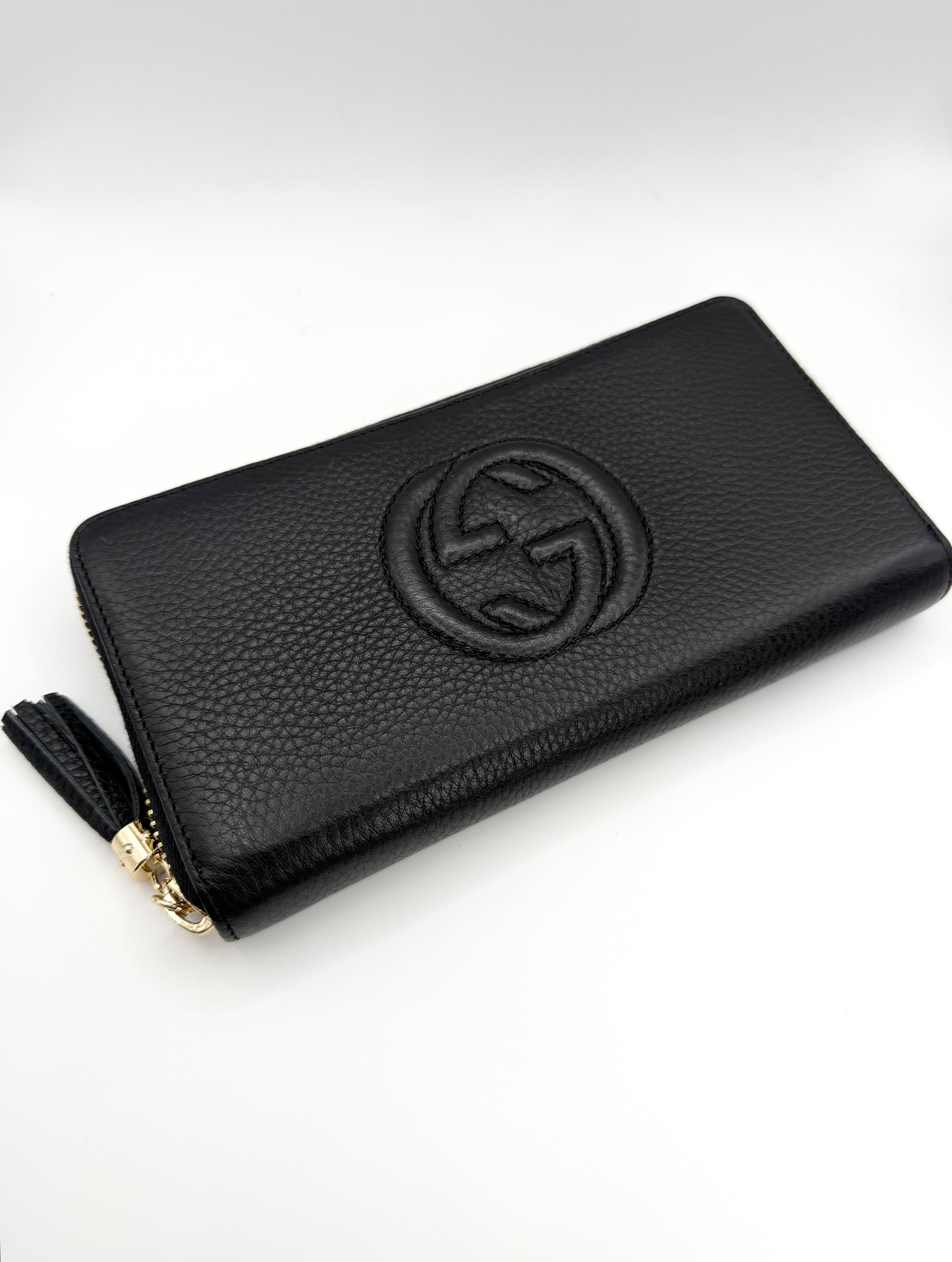 Vintage Gucci Soho Logo Black Pebbled long wallet featuring leather tassel zipper showcased on white background