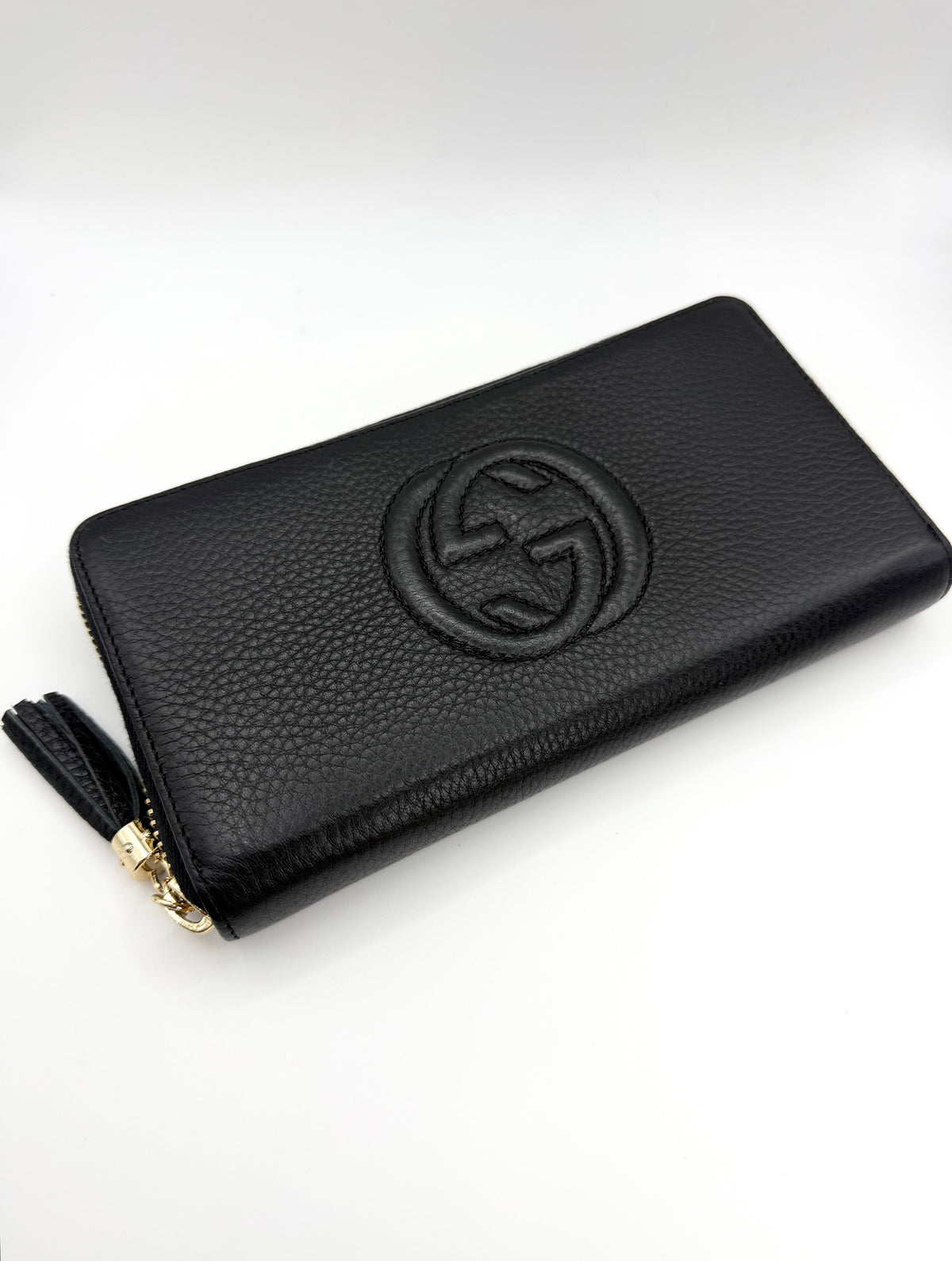 Vintage Gucci Soho Logo Black Pebbled long wallet featuring leather tassel zipper showcased on white background