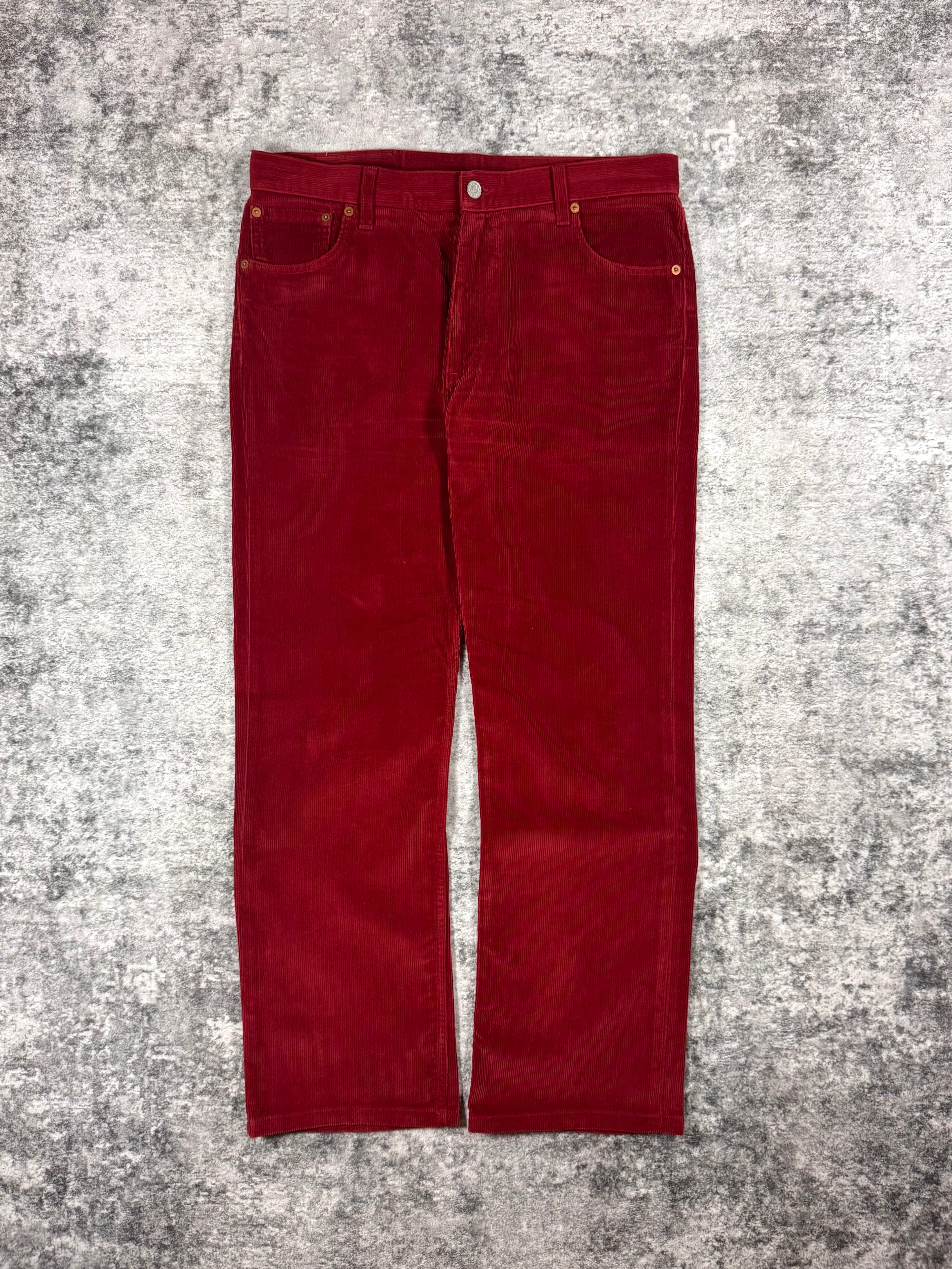 Red Gucci corduroy trousers with leather back patch branding, straight-leg fit, and five-pocket construction, made in Italy.