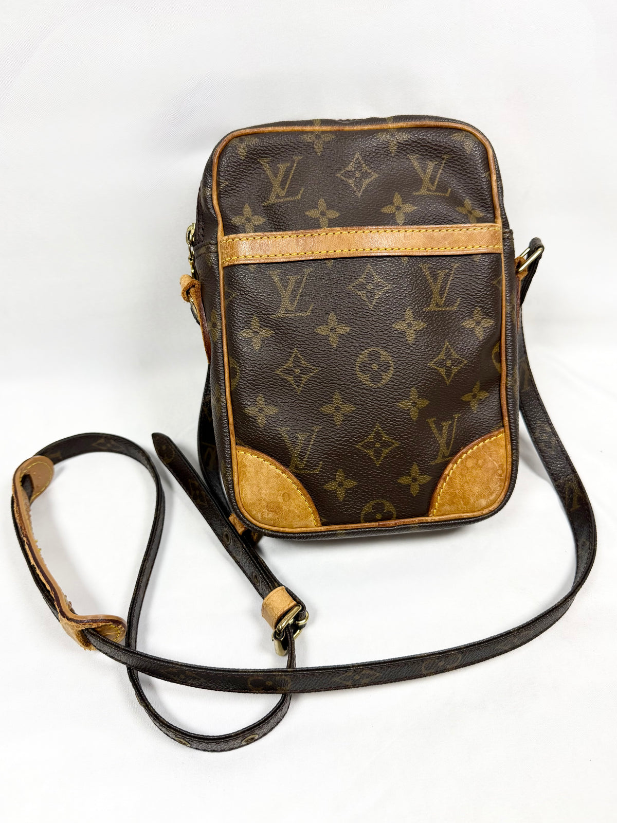 Vintage Louis Vuitton Danube PM Monogram canvas crossbody bag featuring Vachetta leather corners, gold-tone hardware, adjustable shoulder strap, and brown interior lining.
