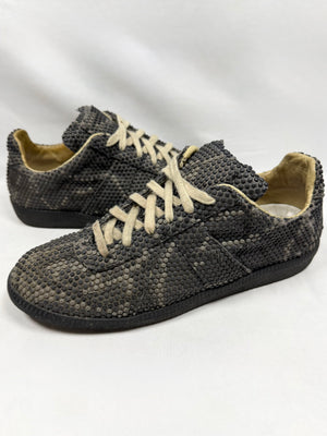 Maison Margiela Replica GAT low sneakers in black and grey python-effect rubber studded texture with cream laces and worn detailing On white background. 
