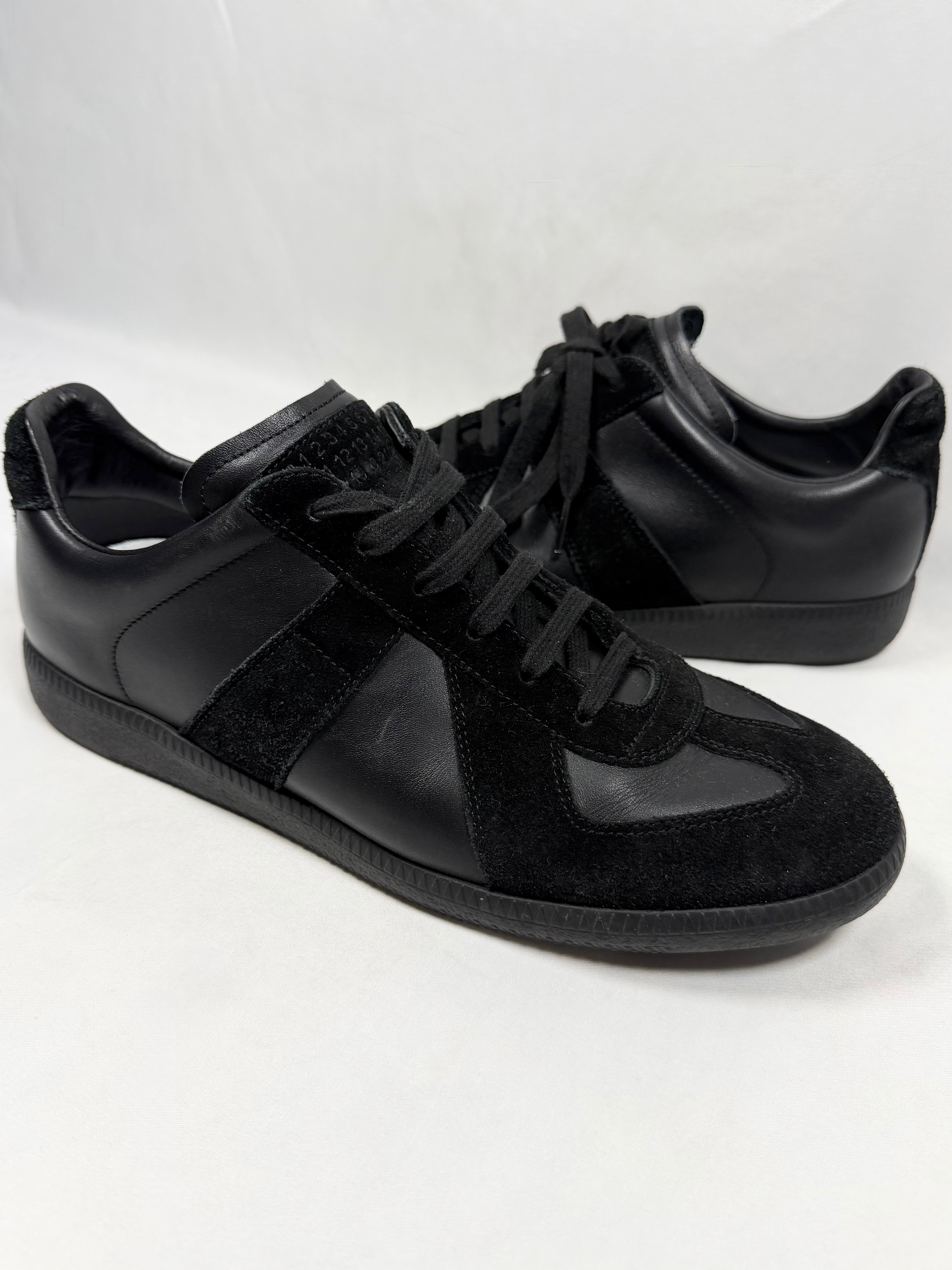 Maison Margiela triple black GAT replica low sneakers in leather and suede with tonal black sole and lace-up front on white background 
