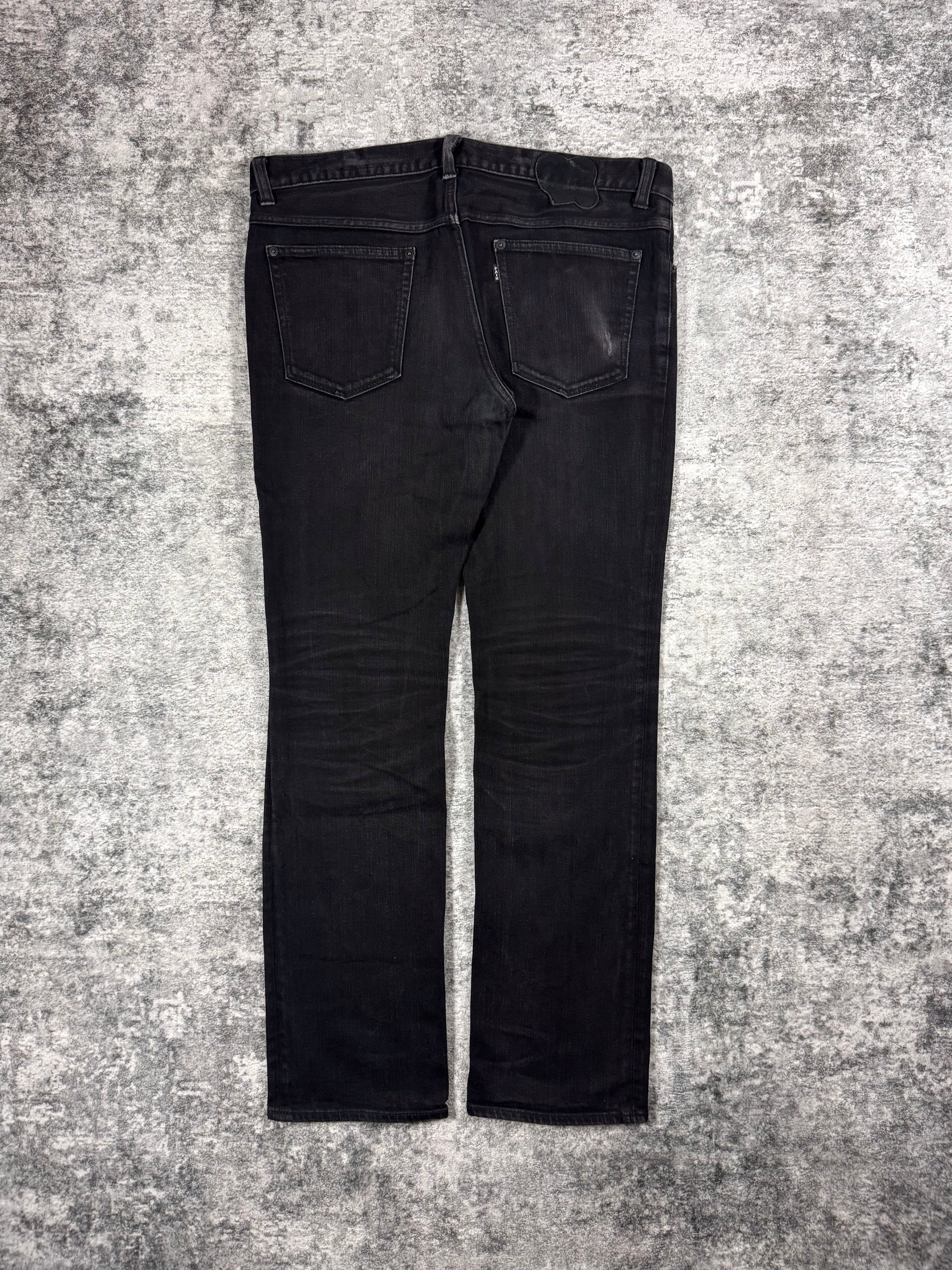 Number (N)ine FW06 black pain denim jeans front view on grey background 