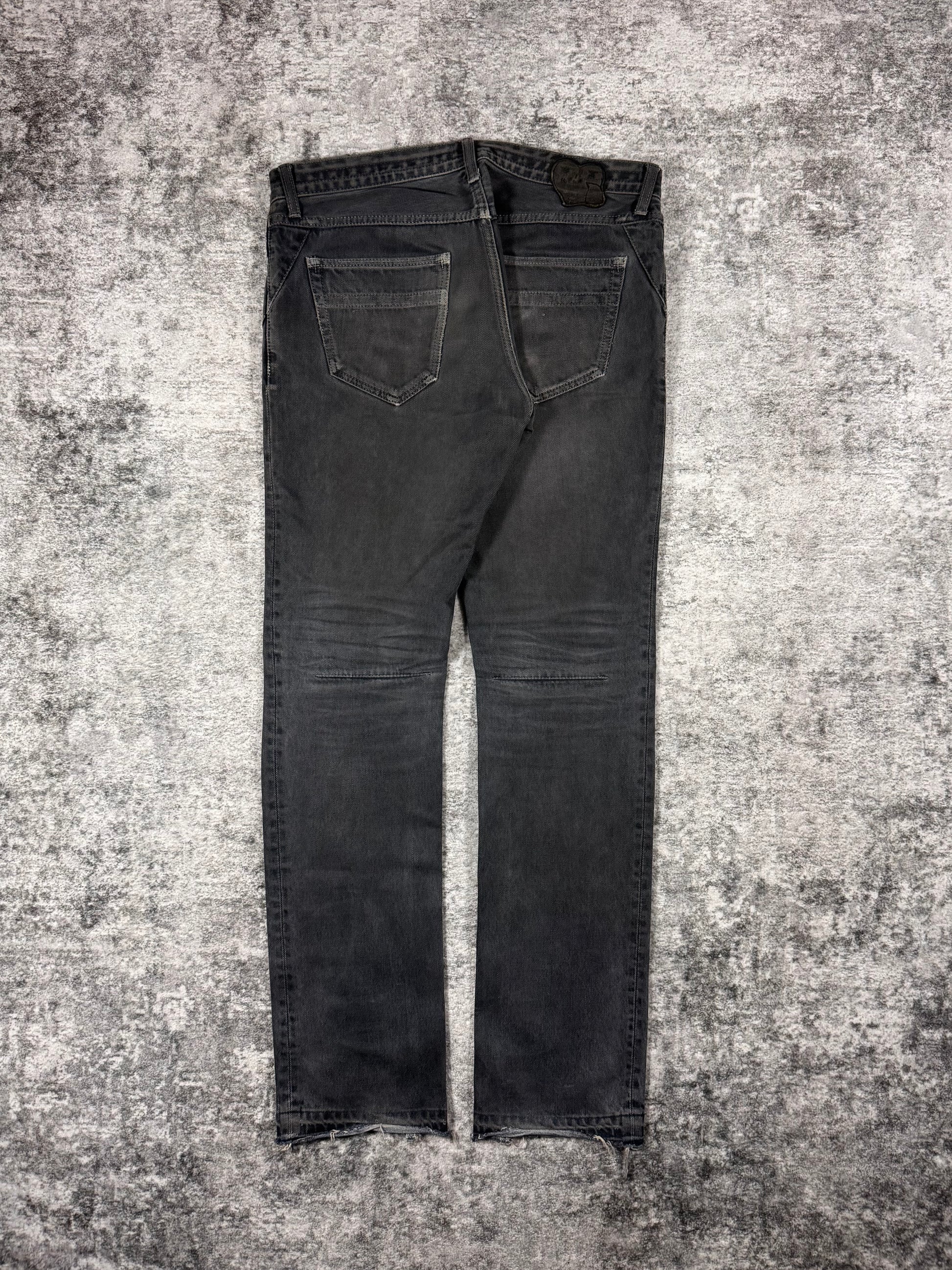 Number Nine denim from Spring Summer 2007 with intentional mud wash effect on the denim with darted thighs, as well as the signature crying heart patch showcased on the rear. Showcased on grey background.