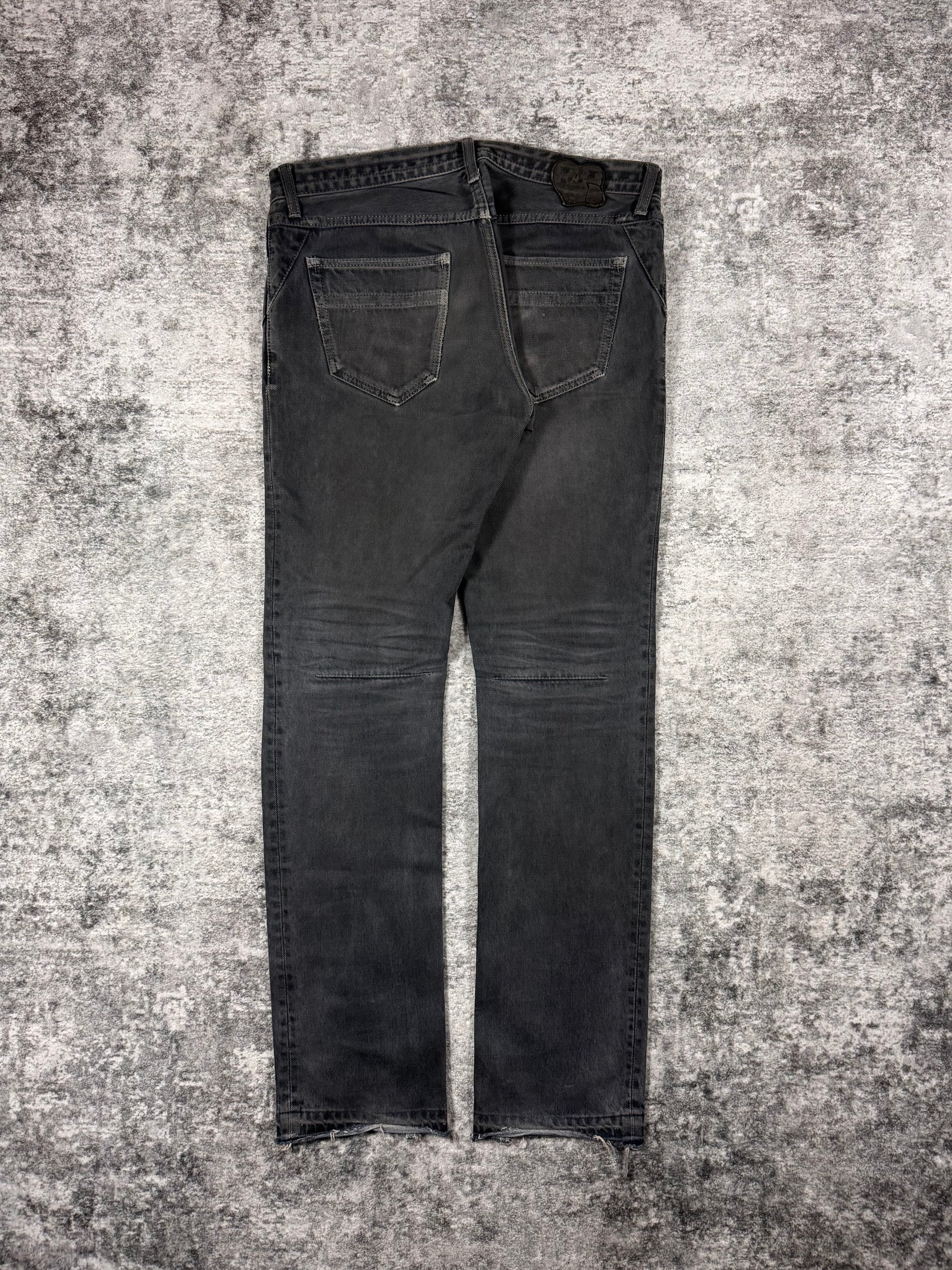 Number Nine denim from Spring Summer 2007 with intentional mud wash effect on the denim with darted thighs, as well as the signature crying heart patch showcased on the rear. Showcased on grey background.