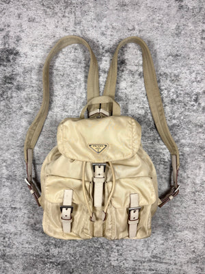 Vintage creams backpack with leather straps on a textured gray background