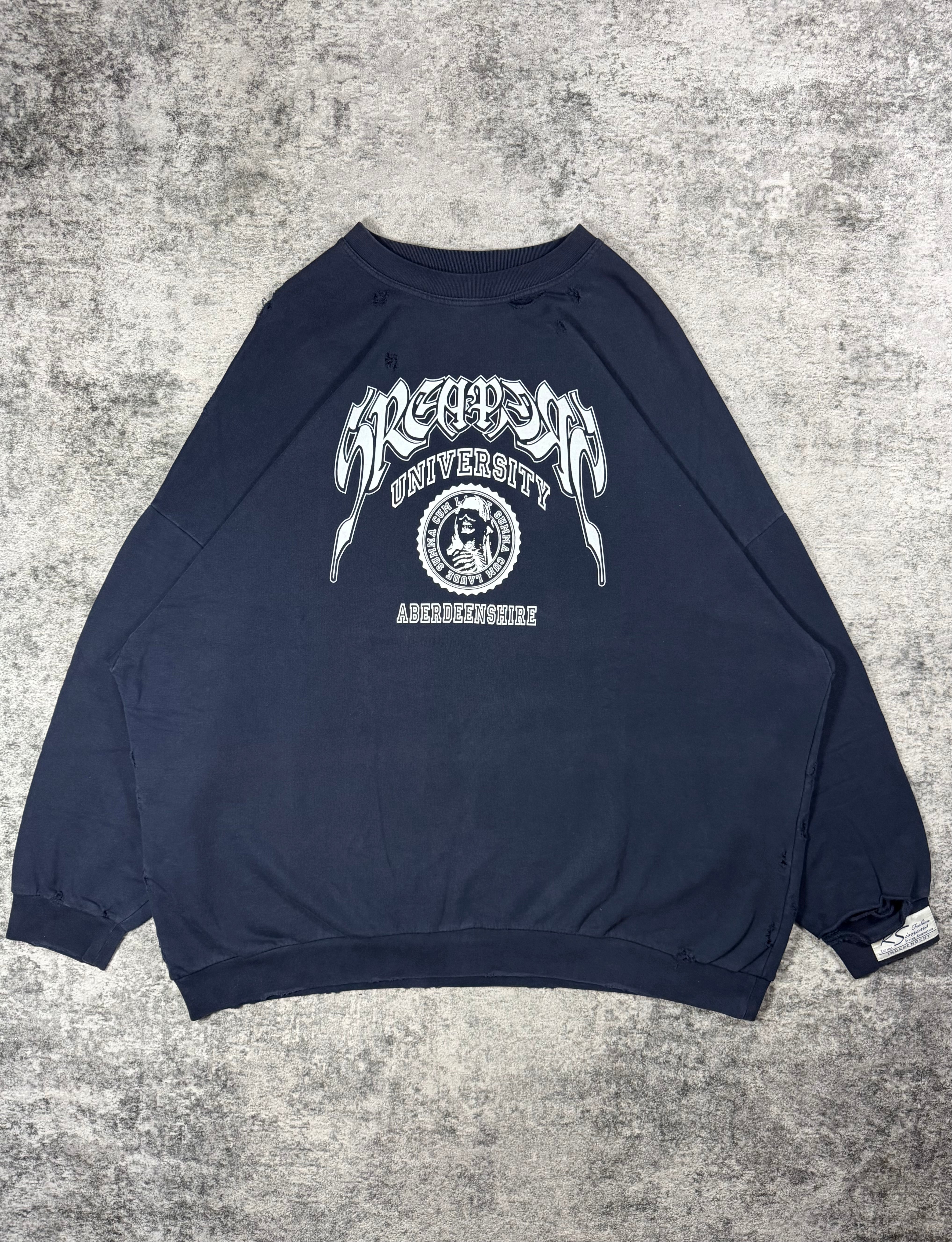 Raf Simons ‘Sreapers University’ Oversized Distress Crewneck from 2022 featuring collegiate inspired logo with a skeleton laid on a grey carpet