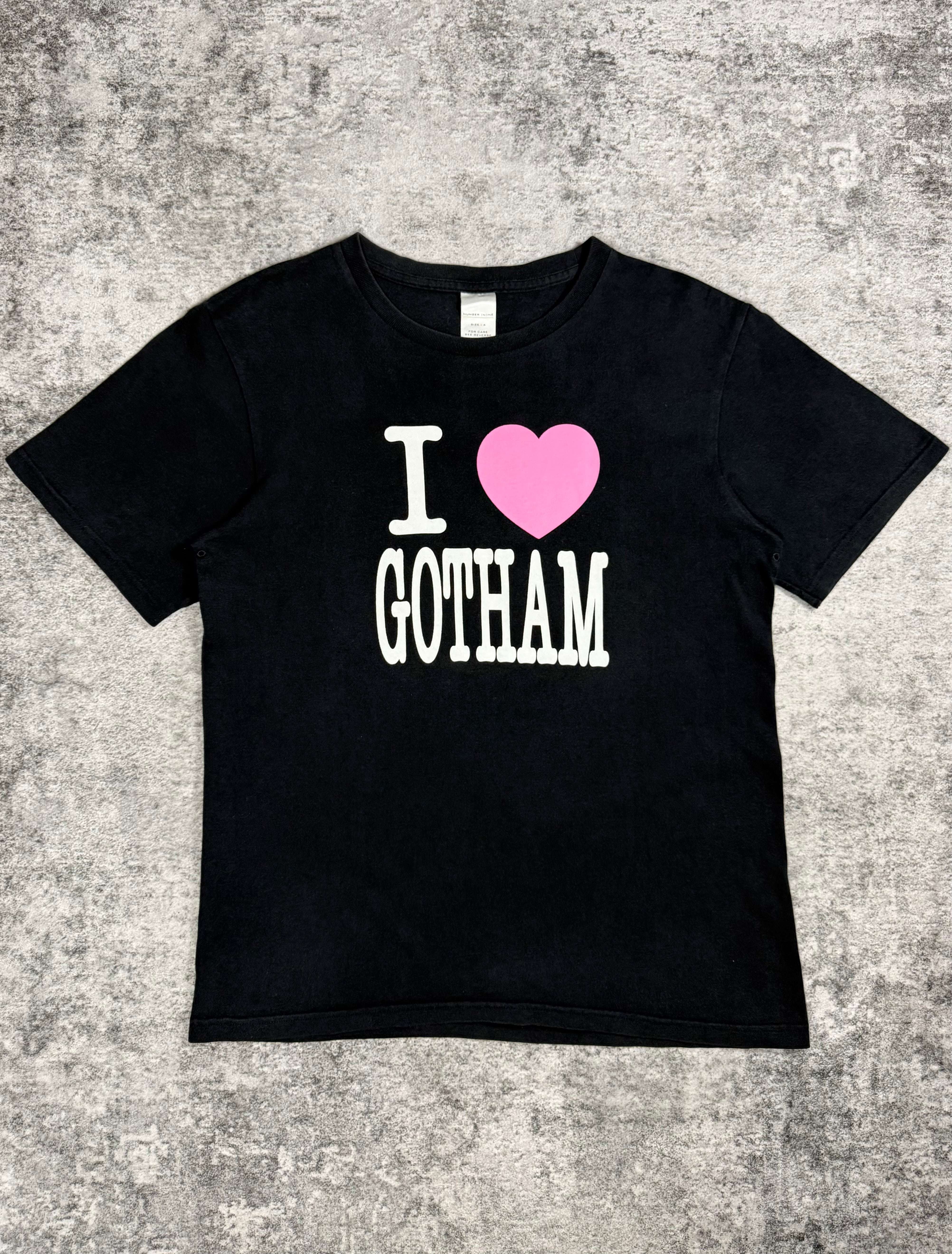 Black Number Nine t-shirt with 'I ❤️ GOTHAM' text on a textured gray background with pink oversized heart 