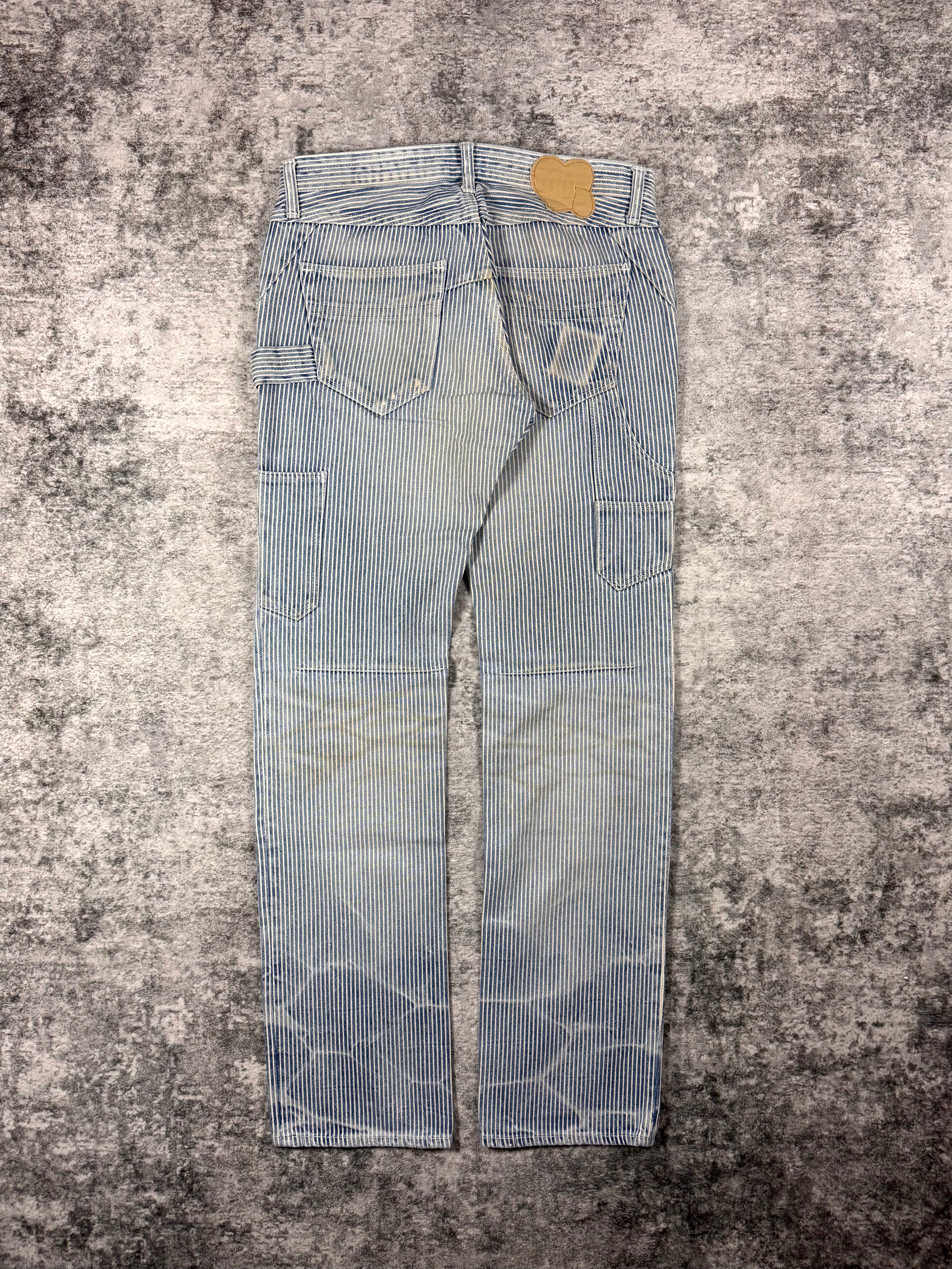 Number (N)ine hickory stripe denim inspired by American hickory stripe patterning and the Levi’s jeans. Laid out on grey carpet.