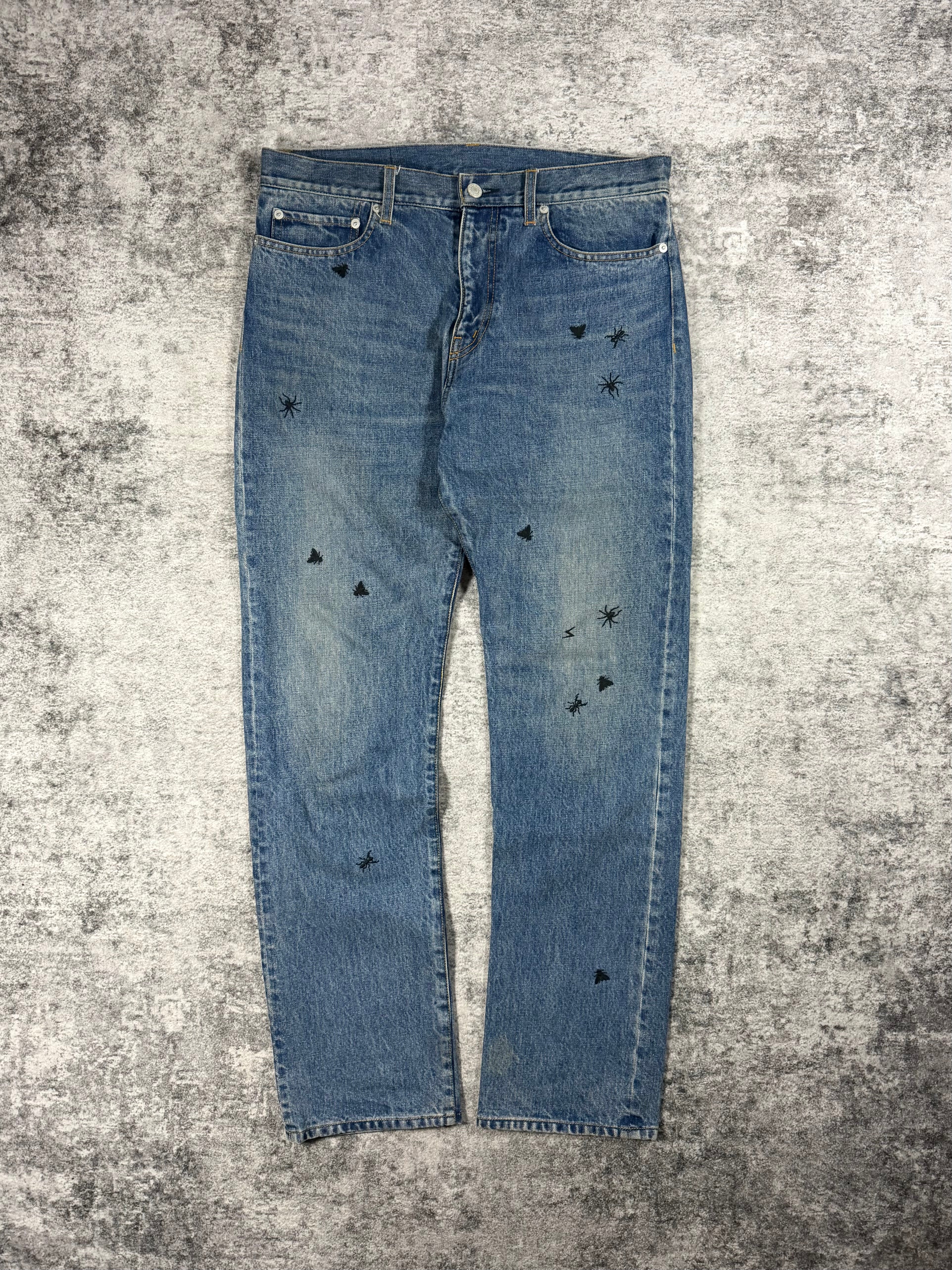 Undercover denim from spring summer 2024 released as a reissue of the iconic big embroidery denim originally released in 2006 Guru Guru showcased on grey carpet.
