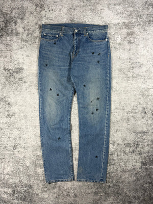 Undercover denim from spring summer 2024 released as a reissue of the iconic big embroidery denim originally released in 2006 Guru Guru showcased on grey carpet.