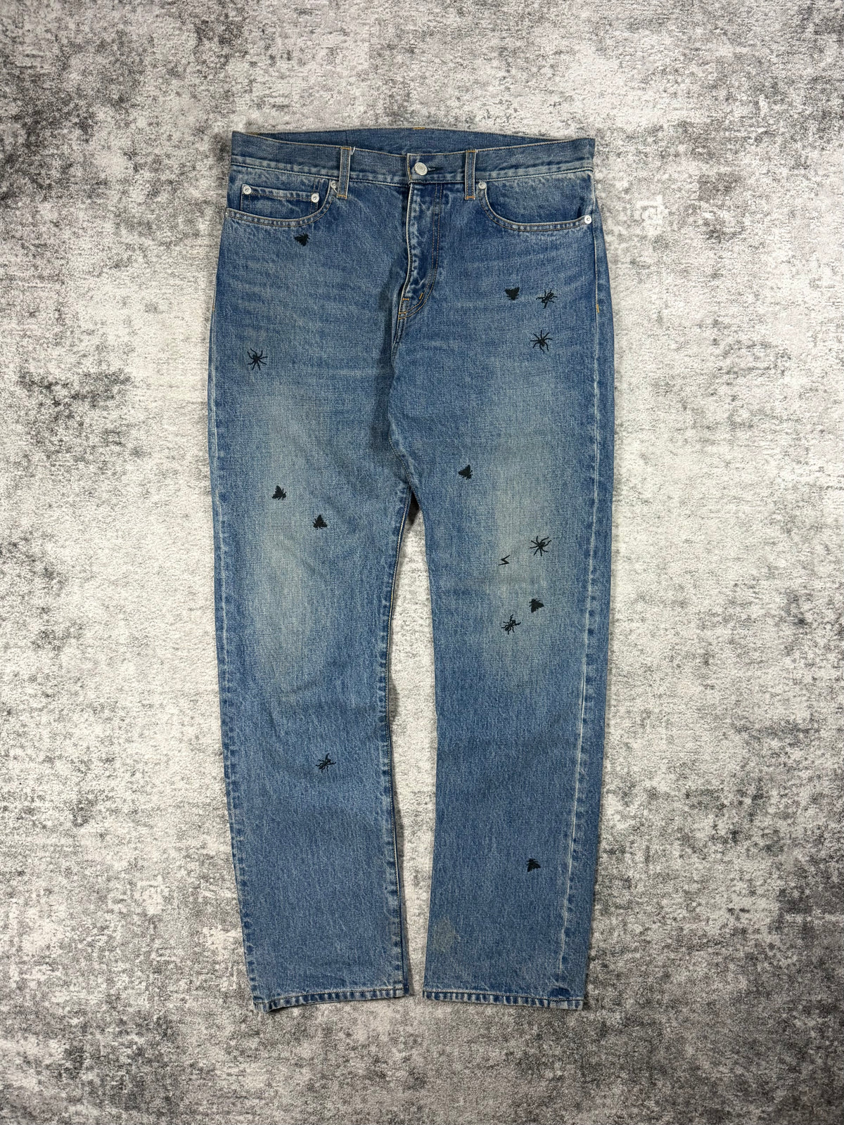 Undercover denim from spring summer 2024 released as a reissue of the iconic big embroidery denim originally released in 2006 Guru Guru showcased on grey carpet.