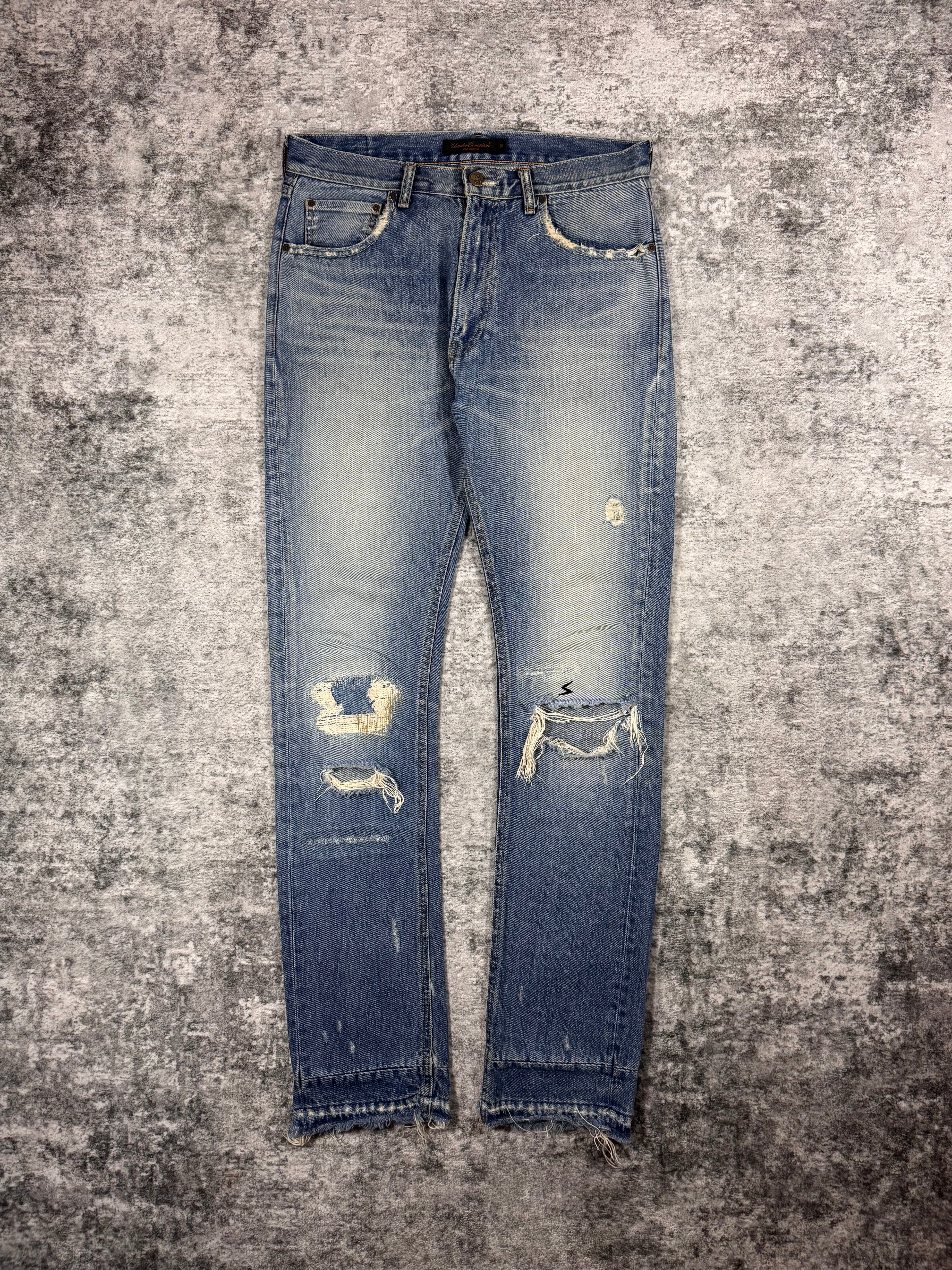 Undercover AW04 But Beautiful distressed indigo denim jeans with repaired knee distressing and vintage fading front view 